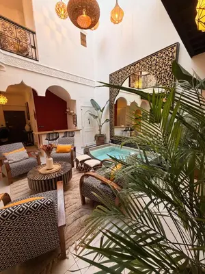 a living room with a pool in a building at Magnifique Riad Julilu Privatise au coeur de la Medina 11P in Marrakech