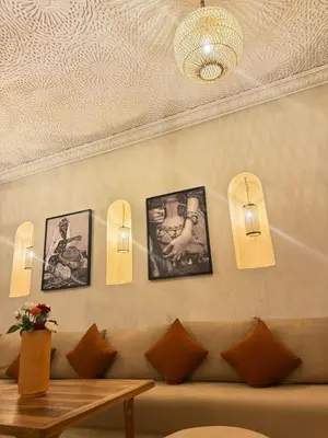 a living room with a couch and pictures on the wall at Riad BB Marrakech in Marrakech
