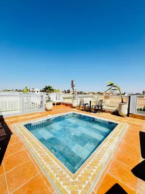 a swimming pool on top of a roof with a patio at Riad BB Marrakech in Marrakech