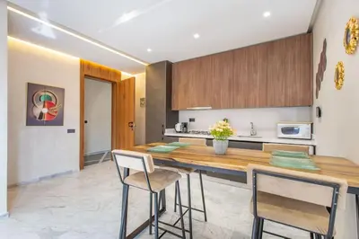 a kitchen with a wooden counter and two stools at New! Marvellous'n modern flat in Marrakech