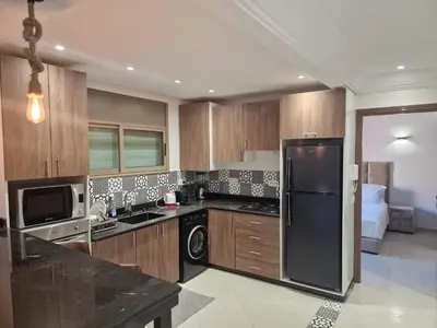 a kitchen with a black refrigerator and a microwave at appartement de luxe face la marllette in Marrakech