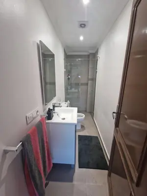 a bathroom with a sink and a toilet and a mirror at appartement de luxe face la marllette in Marrakech