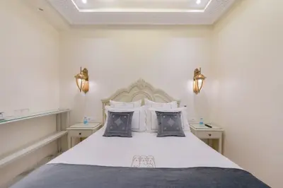 a bedroom with a bed with white sheets and pillows at HOTEL RIAD CHAMI in Marrakech