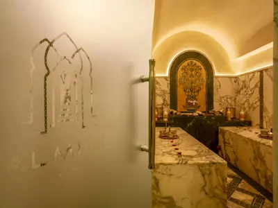 a bathroom with a sink and a wall with graffiti at Riad Almisk in Marrakech