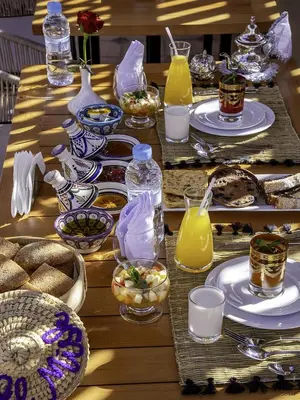 a long table with plates of food and drinks at Riad Almisk in Marrakech