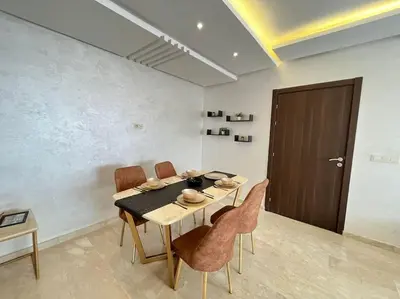 a dining room with a table and chairs and a door at Lovely family condo in residence Marrakech in Marrakech