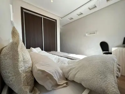 a bedroom with a bed with white sheets and a window at Lovely family condo in residence Marrakech in Marrakech