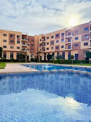 a large swimming pool in front of a building at Appartement en résidence privée in Marrakech