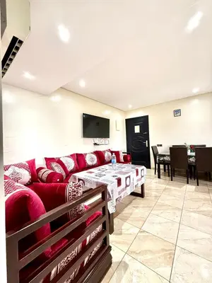a living room with a red couch and a table at Appartement en résidence privée in Marrakech