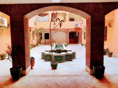 a brick archway with a fountain in a courtyard at Espace Harmony in Marrakech