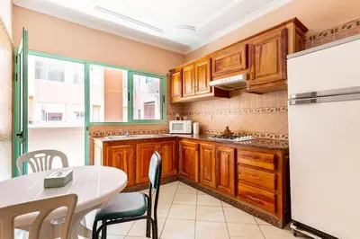 a kitchen with a table and a white refrigerator at Espace Harmony in Marrakech