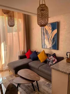 a living room with a couch and a table at Duplex Cosy dans résidence avec piscine in Marrakech