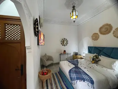 a bedroom with a bed with a blue headboard at RIAD KECHMARA in Marrakech