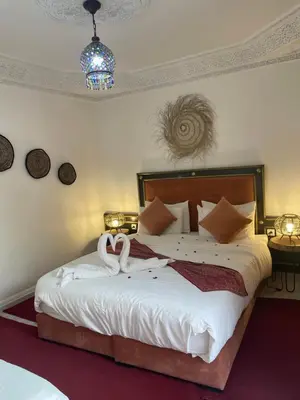 a bedroom with a bed with two swans on it at RIAD KECHMARA in Marrakech