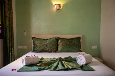 a bed with two towels and a dress on it at Riad Petite Rose in Marrakech