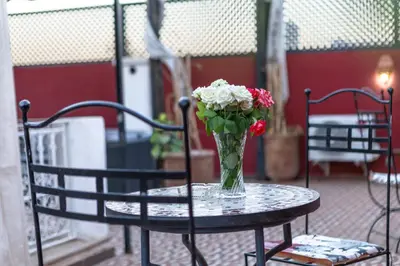 a vase of flowers sitting on a table at Riad Petite Rose in Marrakech