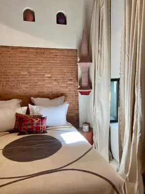 a bedroom with a large bed and a brick wall at Riad Doum Collection 1 in Marrakech