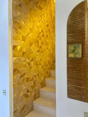 a stairway with a yellow tile wall and stairs at Riad Doum Collection 1 in Marrakech