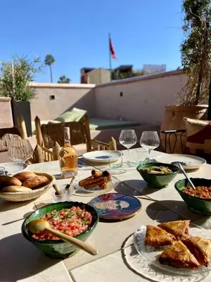 a table with plates of food and glasses of wine at Riad Doum Collection 1 in Marrakech
