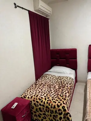 a room with a bed with a cheetah print blanket at 1er étage numéro 5 avec balcon POUR FAMILLE in Marrakech