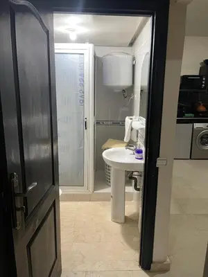 a bathroom with a sink and a toilet and a door at 1er étage numéro 5 avec balcon POUR FAMILLE in Marrakech