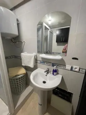 a bathroom with a sink and a mirror at 1er étage numéro 5 avec balcon POUR FAMILLE in Marrakech
