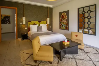 a bedroom with a bed and a table and chairs at Villa Fima Kech in Marrakech