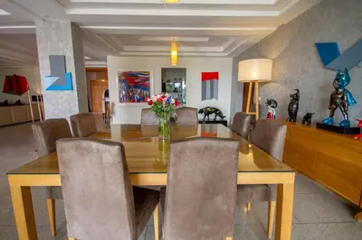 a dining room with a wooden table and chairs at Villa Fima Kech in Marrakech