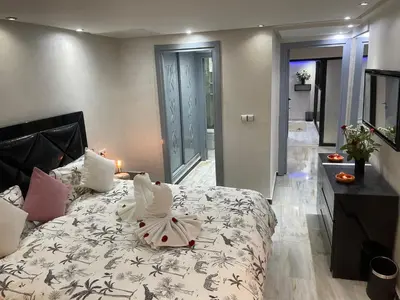 a bedroom with a bed with a white comforter at Appartement en Duplex avec 3 chambres Haut Standing Gueliz Marrakech in Marrakech