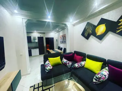 a living room with a black couch with colorful pillows at Nice new apartment in the city center in Marrakech