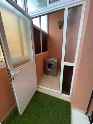 a bathroom with a door and a washing machine at Nice new apartment in the city center in Marrakech
