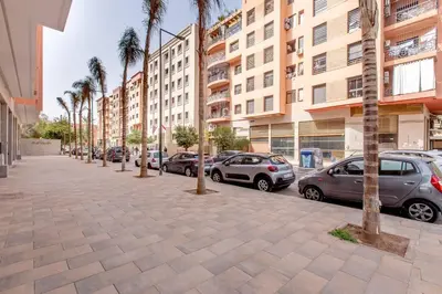 a street with parked cars and palm trees in a city at New ! Splendid and cosy apartment in Marrakech