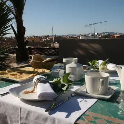 a table with plates of food and cups on it at Riad Pourpre Medina in Marrakech