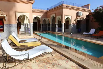 a swimming pool with lounge chairs next to a building at Riad Ben in Marrakech