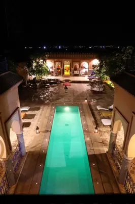 an overhead view of a swimming pool at night at Riad Ben in Marrakech