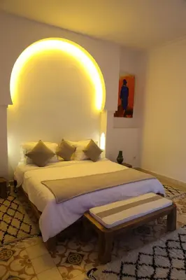 a bedroom with a bed with a yellow light above it at Riad Ben in Marrakech