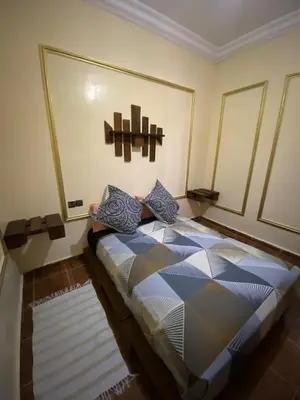 a bedroom with a bed in the corner of a room at Calm appartment close to airport of Marrakech in Marrakech