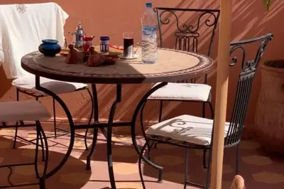 a small table with two chairs and a bottle of water at Dar Khadija Familly in Marrakech