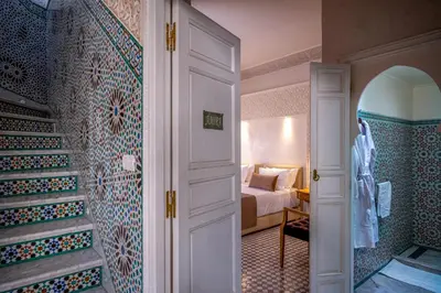 a room with a bed and a bathroom with a door at Riad Glatt K in Marrakech