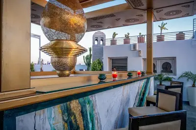 a bar at a hotel with a large light fixture at Riad Glatt K in Marrakech