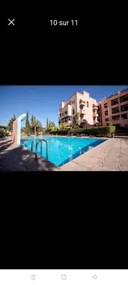 a picture of a swimming pool in front of some buildings at appaartement M23 premium village in Marrakech