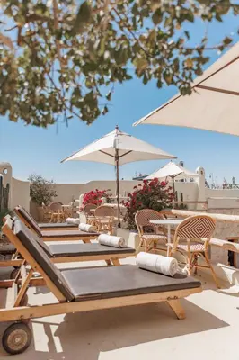 a row of chairs and tables with umbrellas at Pure House Marrakech in Marrakech
