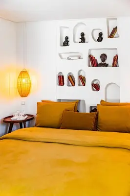 a bedroom with a yellow bed and some plates on the wall at Pure House Marrakech in Marrakech