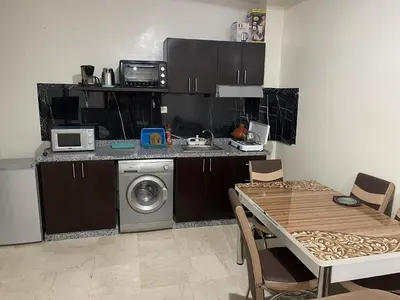 a kitchen with a washing machine and a table with chairs at Appartement 17 3ème étage avec balcon POUR FAMILLE in Marrakech