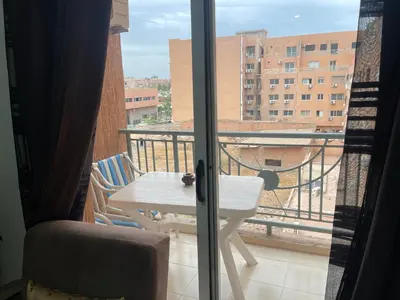 a balcony with a table and a view of a building at Appartement 17 3ème étage avec balcon POUR FAMILLE in Marrakech