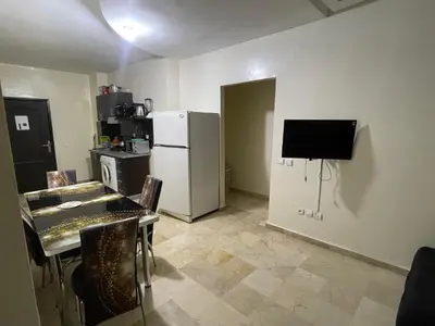 a kitchen with a refrigerator and a table with chairs at Appartement 10 1èr étage. POUR FAMILLE in Marrakech