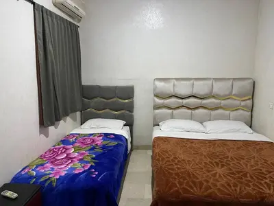 a room with two beds and a window at Appartement 11 2èm étage. (POUR FAMILLE) in Marrakech