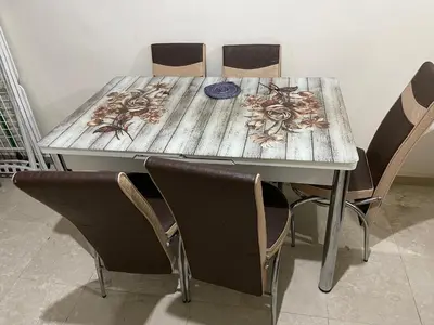 a wooden table with four chairs around it at Appartement 11 2èm étage. (POUR FAMILLE) in Marrakech