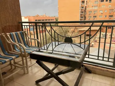 a balcony with a glass table and two chairs at Appartement 11 2èm étage. (POUR FAMILLE) in Marrakech