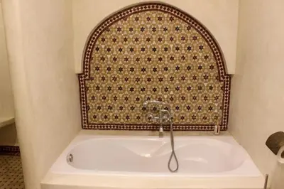 a bath tub in a bathroom with a wall at DAR NOUONSA in Marrakech
